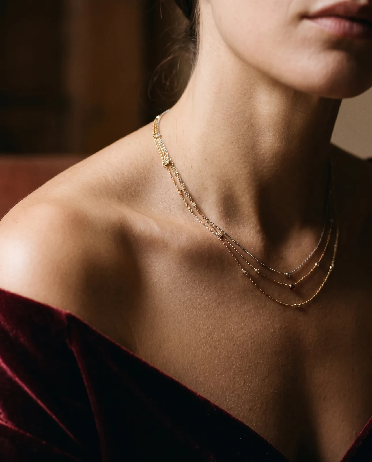 Layered fine gold chains on a collarbone