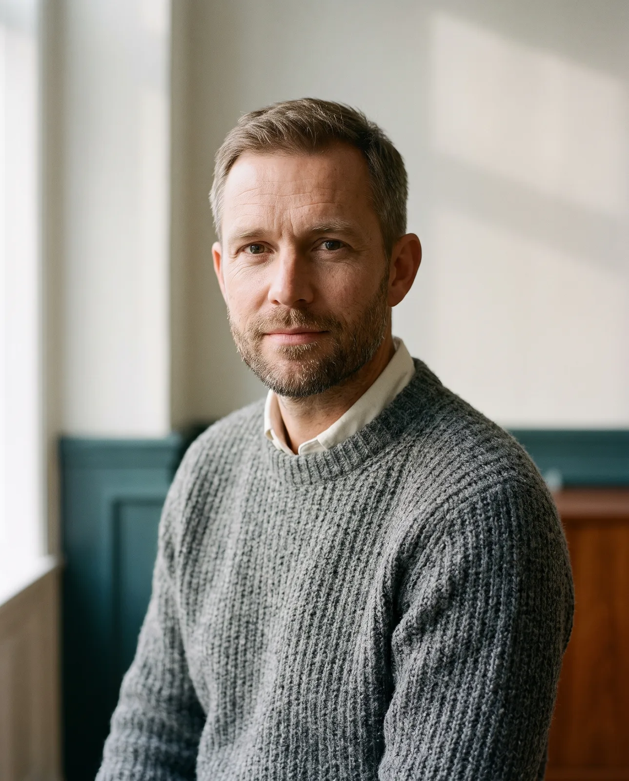 Portrait of Jonas Halde, a man in his forties with a short beard and a grey jumper