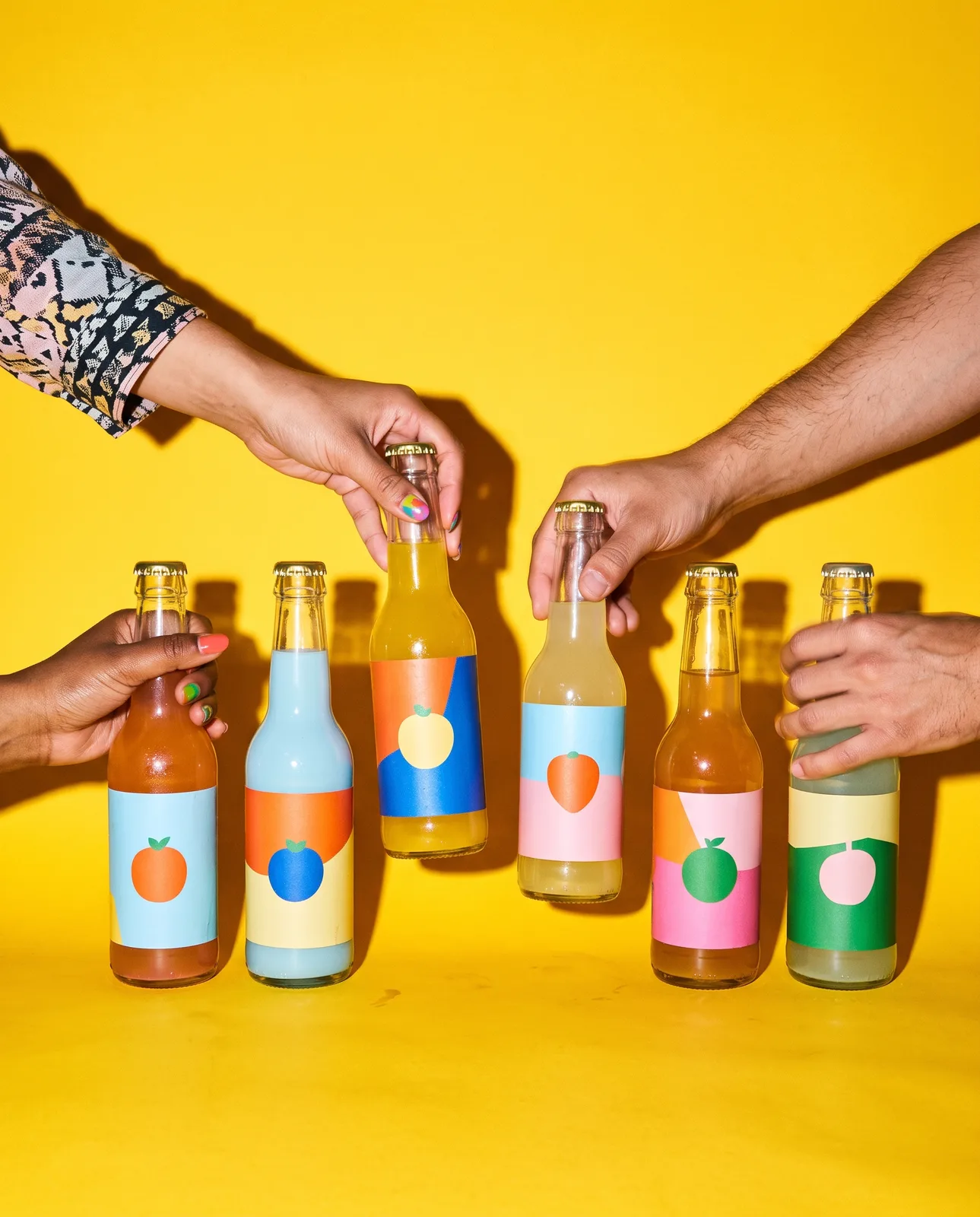 Drink bottles with bold colour-block labels on a yellow backdrop