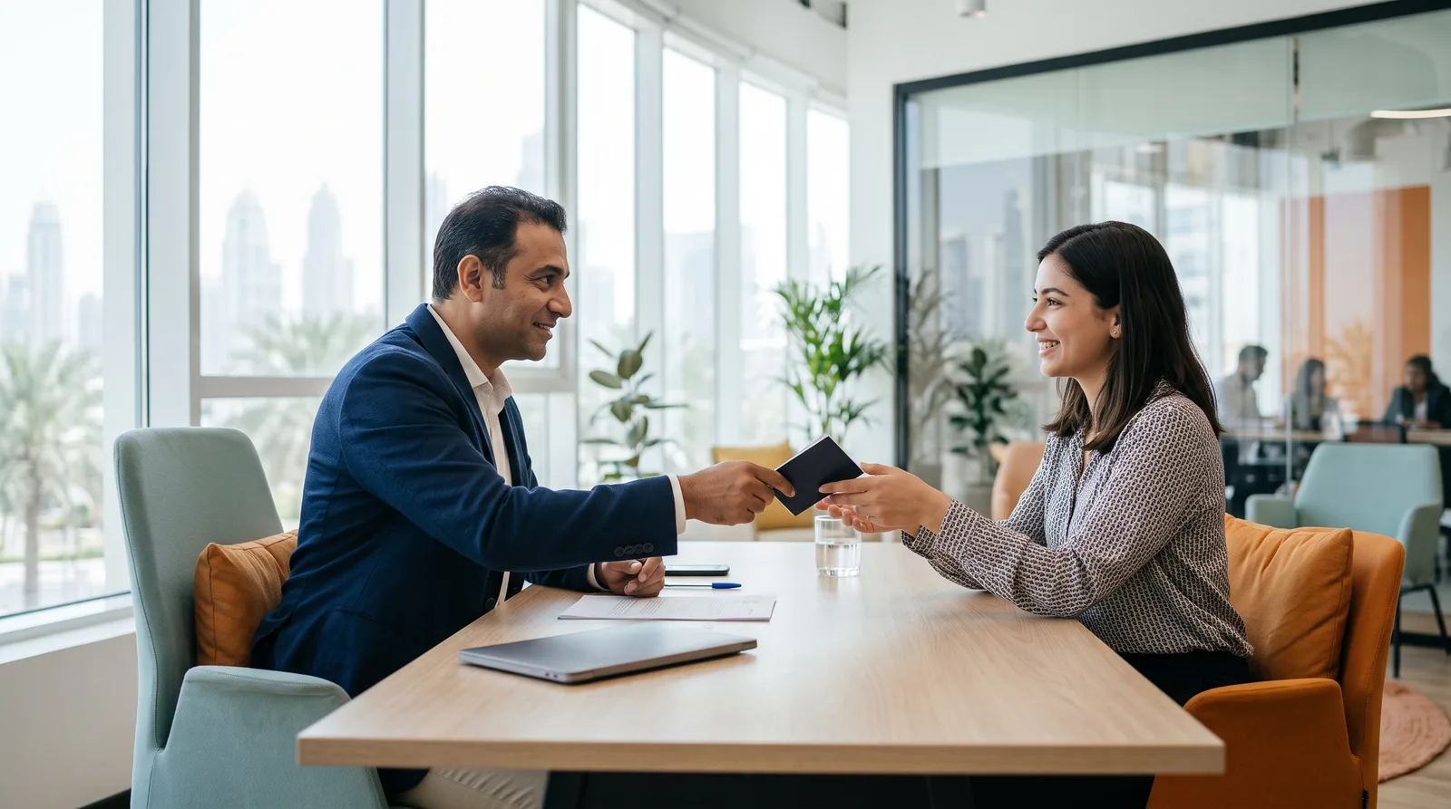 An adviser handing a client her passport across a bright office desk