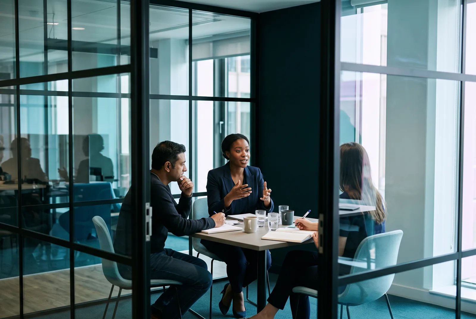 Data lead presenting to two colleagues in a small meeting room